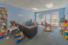 A large carpeted room with children's toys